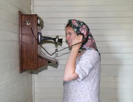 A young woman using a historic telephone