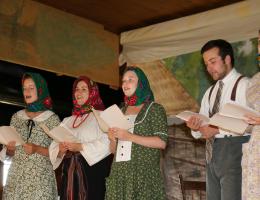 People standing in a line wearing historic Ukrainian clothing and singing